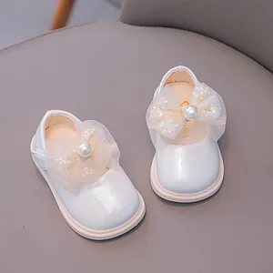 White Mary Jane baby shoes with large tulle bow and pearl accents for toddlers