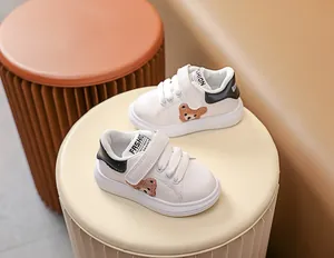 Détail de baskets pour bébé avec broderie d'ours brun et fermeture à scratch