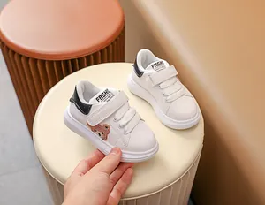 Détail de baskets blanches pour bébés avec broderie ours et sangles velcro