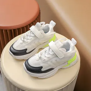 Detail of kids sporty sneakers featuring white mesh, black leather toe and neon green heel