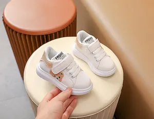 Détail de baskets pour bébé avec patch ours en peluche et fermeture à scratch