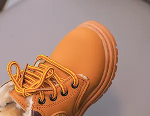 Detailopname van warme gele kinderlaarzen met dikke pluche voering en stevige veters