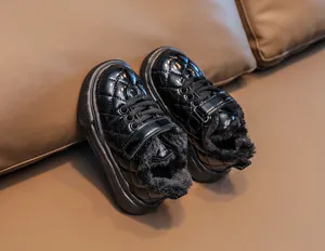 Close-up of kids' black quilted patent leather winter boots with thick faux fur lining