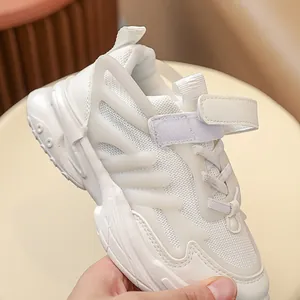 Close-up of children's white running shoes with breathable mesh and velcro straps