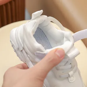 Macro detail of breathable mesh lining and velcro strap on children's white sneakers