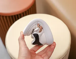 Gros plan d'une basket blanche pour bébé souple avec semelle en caoutchouc pliable