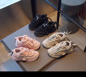 Drei Paar Kinder-Sneaker aus Mesh in Pink, Beige und Schwarz auf einer Lederbank