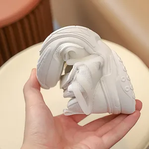 Detailed view showing the flexibility of the soft sole on white children's running shoes
