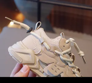 Detailaufnahme von atmungsaktivem Mesh und Lederbesatz am beigen Kinder-Laufschuh