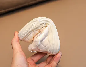 Detail of flexible rubber sole on beige toddler winter boots with warm plush lining