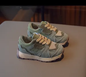 Detail of sage green suede and mesh on kids retro sneakers with brown rubber sole
