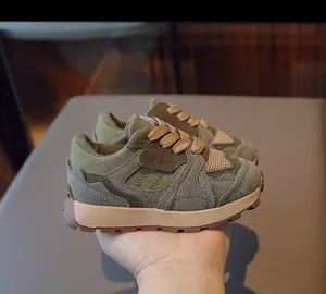 Detailed view of kids vintage sneakers with olive green suede and mesh textures