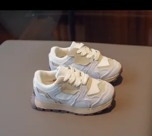 Detail of kids beige and khaki retro mesh sneakers with textured anti-slip rubber soles