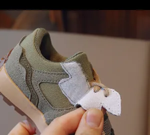 Detail of olive green kids sneaker with breathable mesh and easy Velcro closure