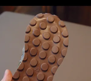 Detail of size 23 non-slip brown rubber sole with textured circular grip for kids shoes