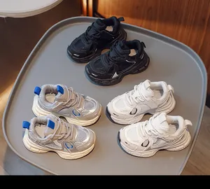 Detail of breathable mesh kids' sneakers in black, silver, and white with non-slip soles