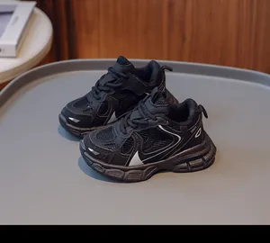 Detail of children's black sneakers featuring breathable mesh and thick anti-slip soles