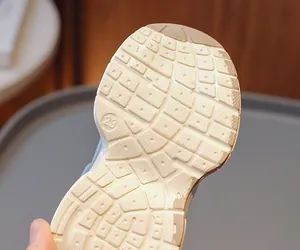 Detailed view of non-slip rubber sole for kids sneakers with traction patterns and size 23