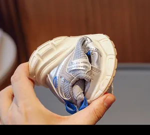 Flexible sole of kids' breathable mesh sneaker being bent to show high elasticity