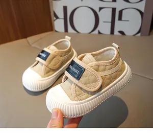 Detailed macro view of quilted beige baby shoes with non-slip rubber soles and velcro