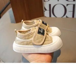 Detail of beige toddler sneakers featuring quilted texture and protective rubber toe cap