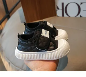 Detail of baby walking shoes featuring quilted black leather and durable rubber soles