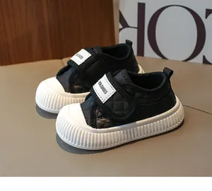 Close-up of black quilted toddler sneakers with thick non-slip soles and velcro straps