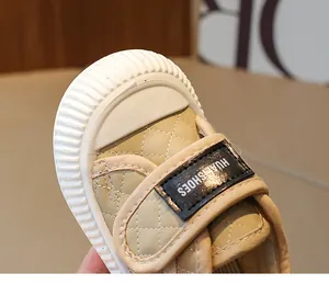Close-up of quilted toddler sneakers featuring rubber toe cap and velcro strap closure