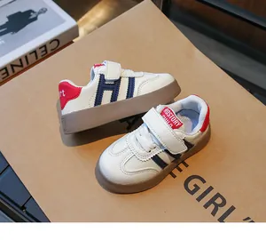 Détail de baskets en cuir enfant avec bandes H bleues et talon rouge décoré