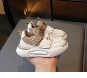 Détail de la chaussure de sport enfant avec cuir blanc et kaki, velcro et semelle souple épaisse