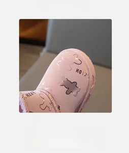 Detail von rosa Mädchen Schneestiefeln mit Goldbär-Muster und warmem Pelzfutter