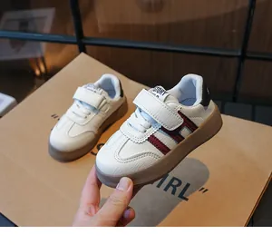 Détails de baskets blanches pour enfants avec rayures rouges et semelle en gomme brune