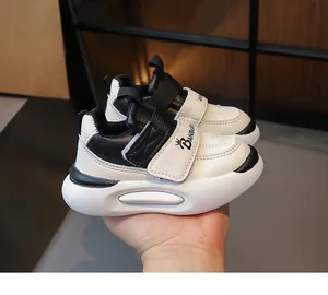 Détail de baskets enfant noir et blanc avec fermeture velcro et semelle antidérapante