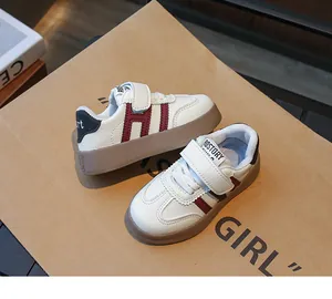 Détail de baskets blanches enfant avec logo H bordeaux et semelle en gomme marron