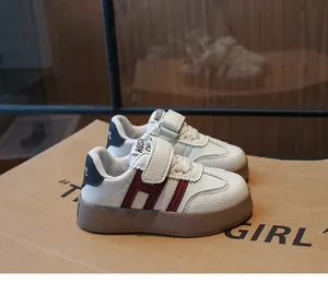 Détail de baskets blanches pour enfants avec accents rouges et semelle en gomme durable