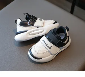 Détails de baskets enfants noir et blanc avec scratch et logo sur fond de cuir texturé