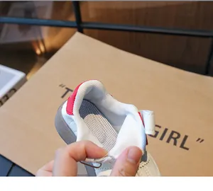 Gros plan détaillé de la basket enfant en cuir blanc avec talon rouge et maille interne