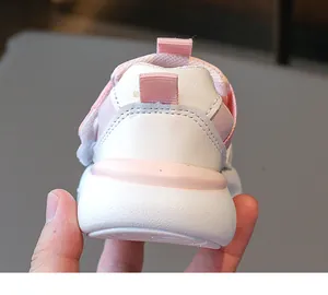 Gros plan d'une chaussure de sport enfant rose et blanc avec semelle épaisse amortissante