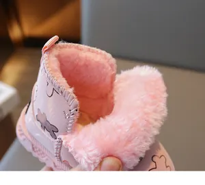 Nahaufnahme der rosa Kinder-Schneestiefel mit dickem Kunstfellfutter und Cartoon-Detail