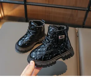 Detail of kids black patent leather boots featuring quilted patterns and rhinestone buckles