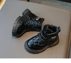 Detail of children black patent leather martin boots with quilted rhombic texture