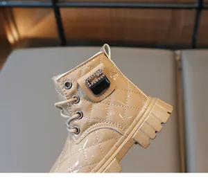 Close-up of khaki patent leather kids boot with diamond buckle and quilted pattern
