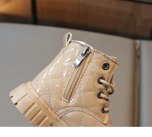 Detail of children's patent leather boots showing quilted stitching and side zipper