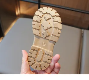 Close-up of children's khaki boots featuring non-slip rubber soles with deep grip patterns