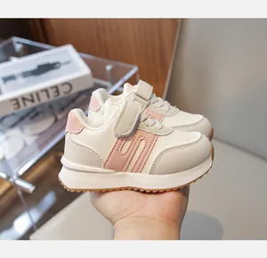 Dettaglio di scarpe sportive per bambini in pelle beige con velcro e inserti rosa
