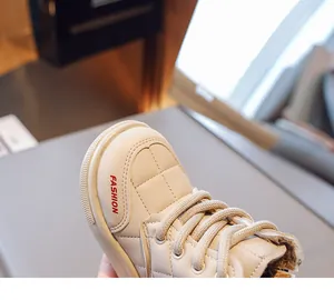 Close-up of beige quilted children winter boots with warm brown faux fur lining and laces