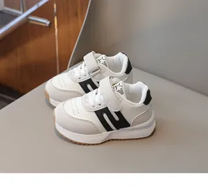 Dettaglio di sneaker bianche per bambini con motivo a stella e chiusura a strappo