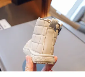 Detail showing beige quilted faux leather kids snow boots with zipper and non-slip rubber sole