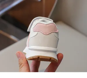 Dettaglio del tallone rosa e delle cuciture su scarpe da corsa per bambini con suola in gomma