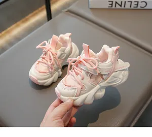 Detail view of pink and white breathable mesh upper on kid's sports sneakers